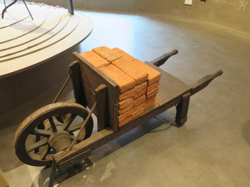 'Voel maar hoe zwaar' Kruiwagen met stenen in Waterliniemuseum bij Fort Vechten. 
