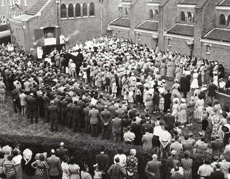 De kerk werd op 21 maart 1929 ingewijd. Op de foto een processie in de jaren 20 op het terrein van de kerk. Eigenlijk was een processie op straat verboden, maar omdat het op eigen terrein gebeurde, kon men dit ongestraft doen.