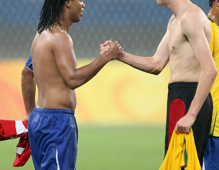 Zoals gebruikelijk schudden spelers elkaar de hand en wisselen van shirt na afloop van de wedstrijd. Hier zien we de Braziliaan Ronaldinho met de Belg Simaeys dat doen tijdens de Olympische Spelen in China (2008). EPA/MARCELO SAYAO