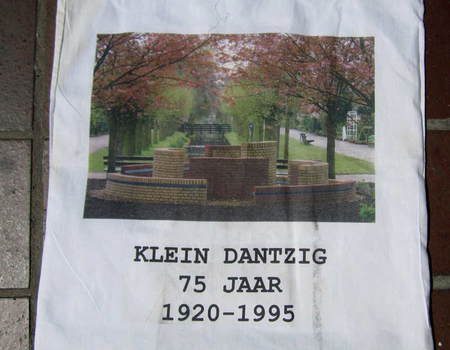 T.g.v. het 75 jaar bestaan van Klein Dantzig werd door Agnes van Genderen een stenen kunstwerk gemaakt, afgebeeld op dit tasje, wat qua vorm een beetje doet denken aan de oude fontein, die bij de ingang aan de Ringdijk stond.