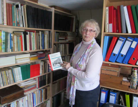 Mevr. Elika Kruizinga-Poll tussen de boeken van haar man.