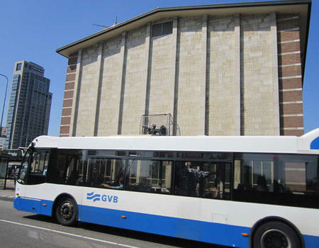 Bus 62 rijdt langs het station. Op de achtergrond de Mondriaantoren.