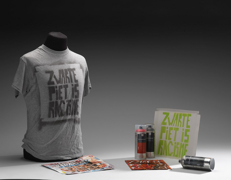 T-shirt, schablonen en spuitbussen van Quinsy Gario voor het kunstproject Zwarte Piet Is Racisme (2011-2012), in 2013 door hem aan het museum geschonken.