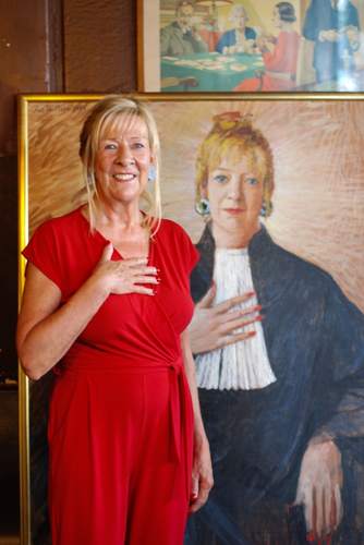 Karin van Ringen voor het portret dat Aat Veldhoen van haar schilderde. foto Karin Pastoor