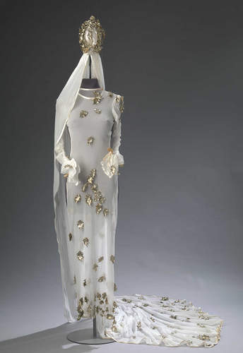 Deze sprookjesachtige bruidsjurk is, net als de kroon,  voorzien van met de hand opgenaaide, goud geverfde hulstblaadjes (1992). 